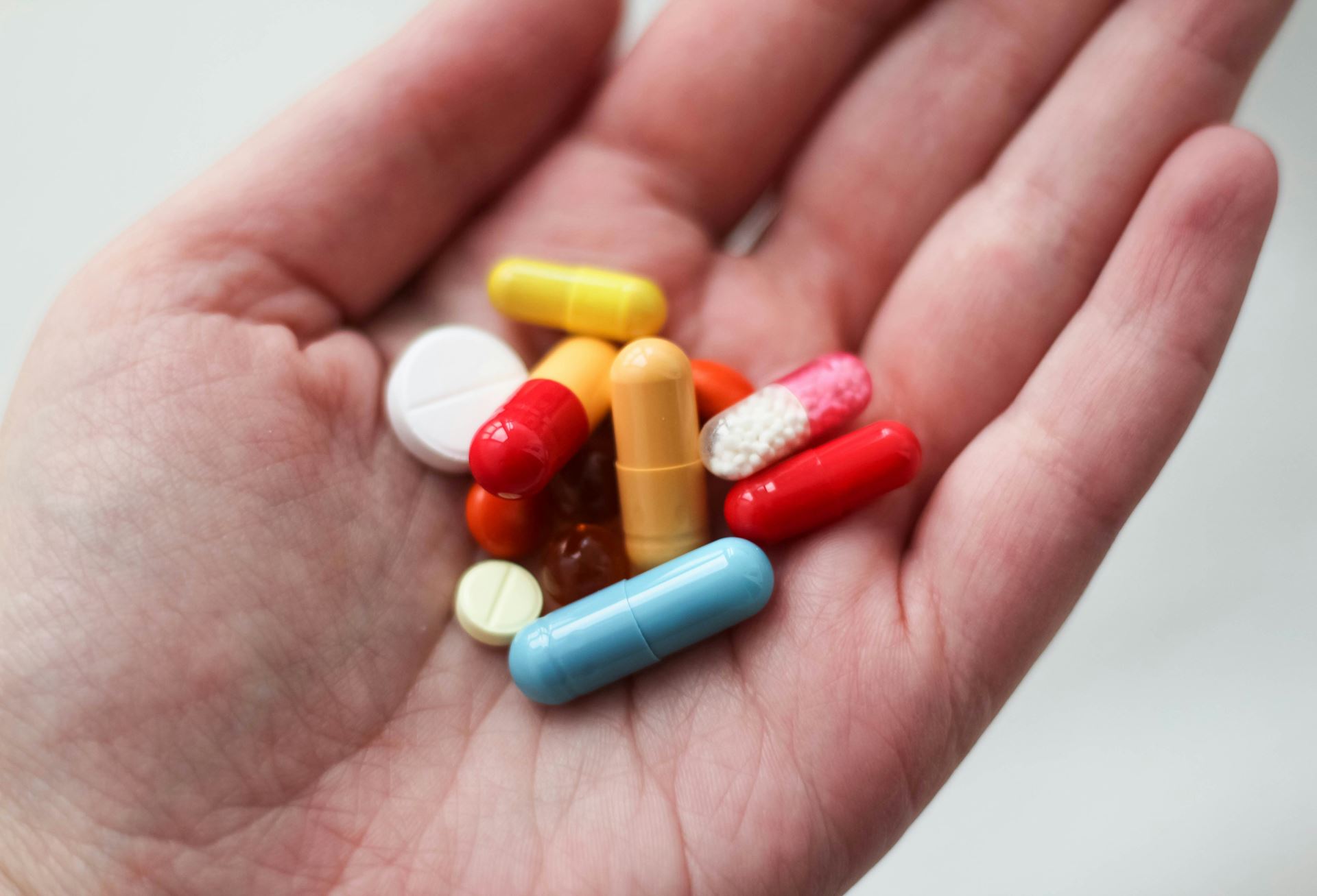 a person holding different types of medicines