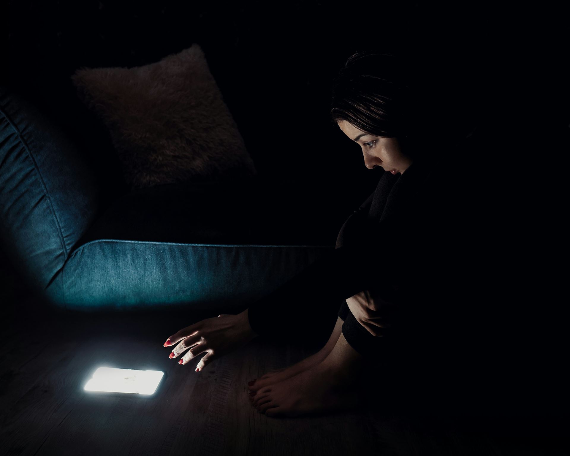 a woman in a dark room looking despondent